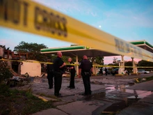 Police officers stand guard as crowds gather for a second night near a BP gas station that was burned after an officer-involved killing Aug. 14, 2016 in Milwaukee. 