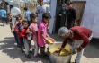 Charitable organizations distribute food to displaced people in shelter tents in Deir al-Balah in the central Gaza Strip on June 9, 2024.